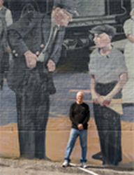Alabama Heritage_Dothan’s mural program was the brainchild of former mayor Larry C. Register, seen here next to a portrait of his father, Alley J. Register, who worked for the Central Georgia Railroad for 45 years. (Robin McDonald)
