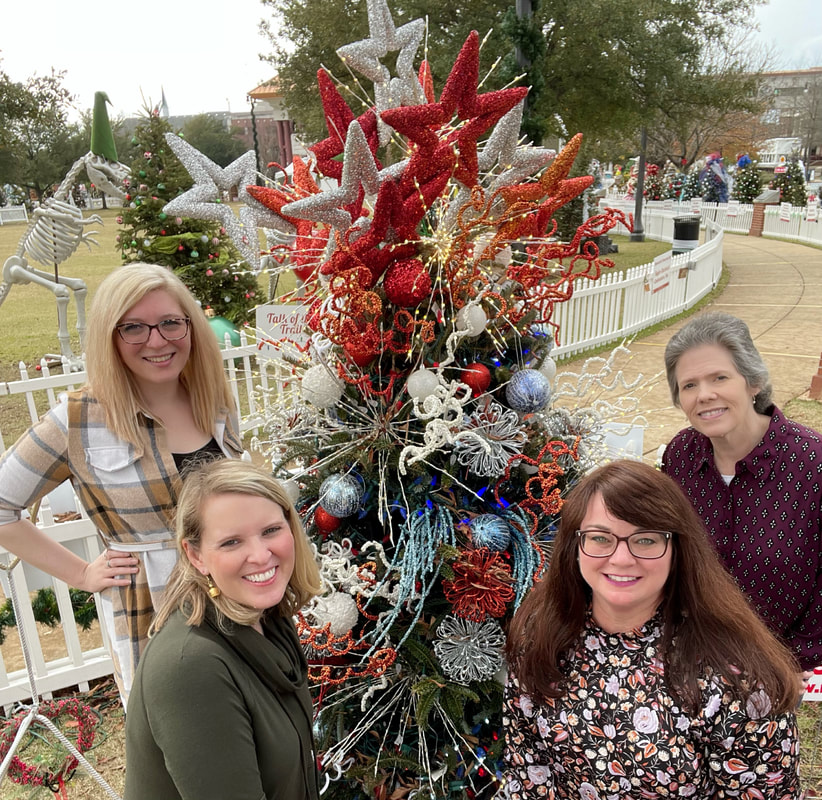The Alabama Heritage Team, comprised of four women, pose at the Tuscaloosa Tinsel Trail, an annual holiday event.