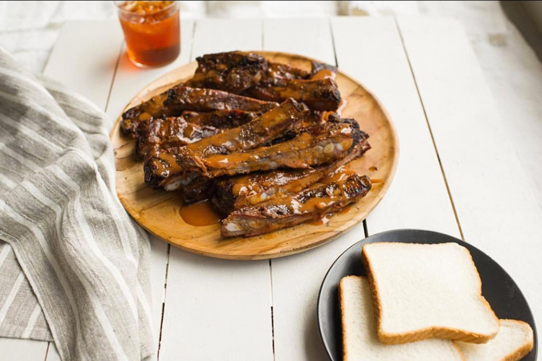BBQ ribs, sliced white bread and a glass of sweet tea.