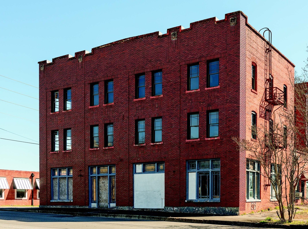 A red brick building stands three stories tall.